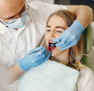 Dentista atendiendo a una joven paciente